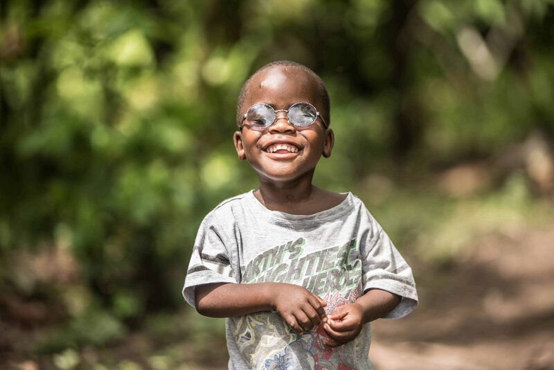 Image of Criscent Bwambale, wearing his new glasses and smiling.