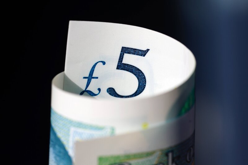 Close up photo of a rolled up five pound note