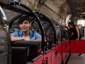 A young man smiling on the mail rail train