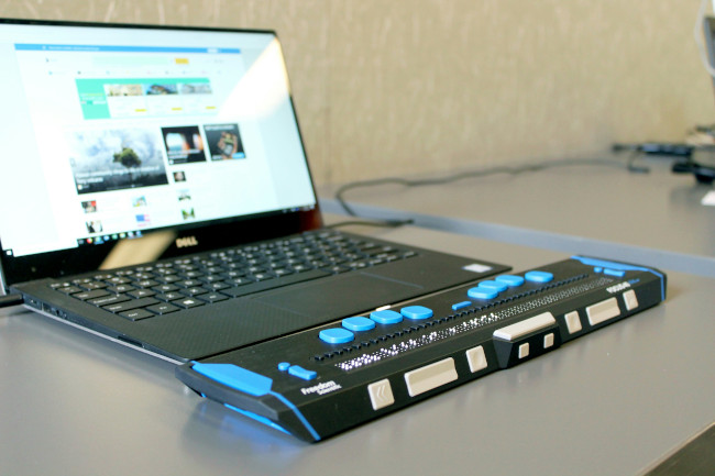 Refreshable Braille display in front of a laptop