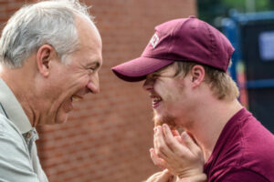 A father and his autistic son looking at each other and smiling 